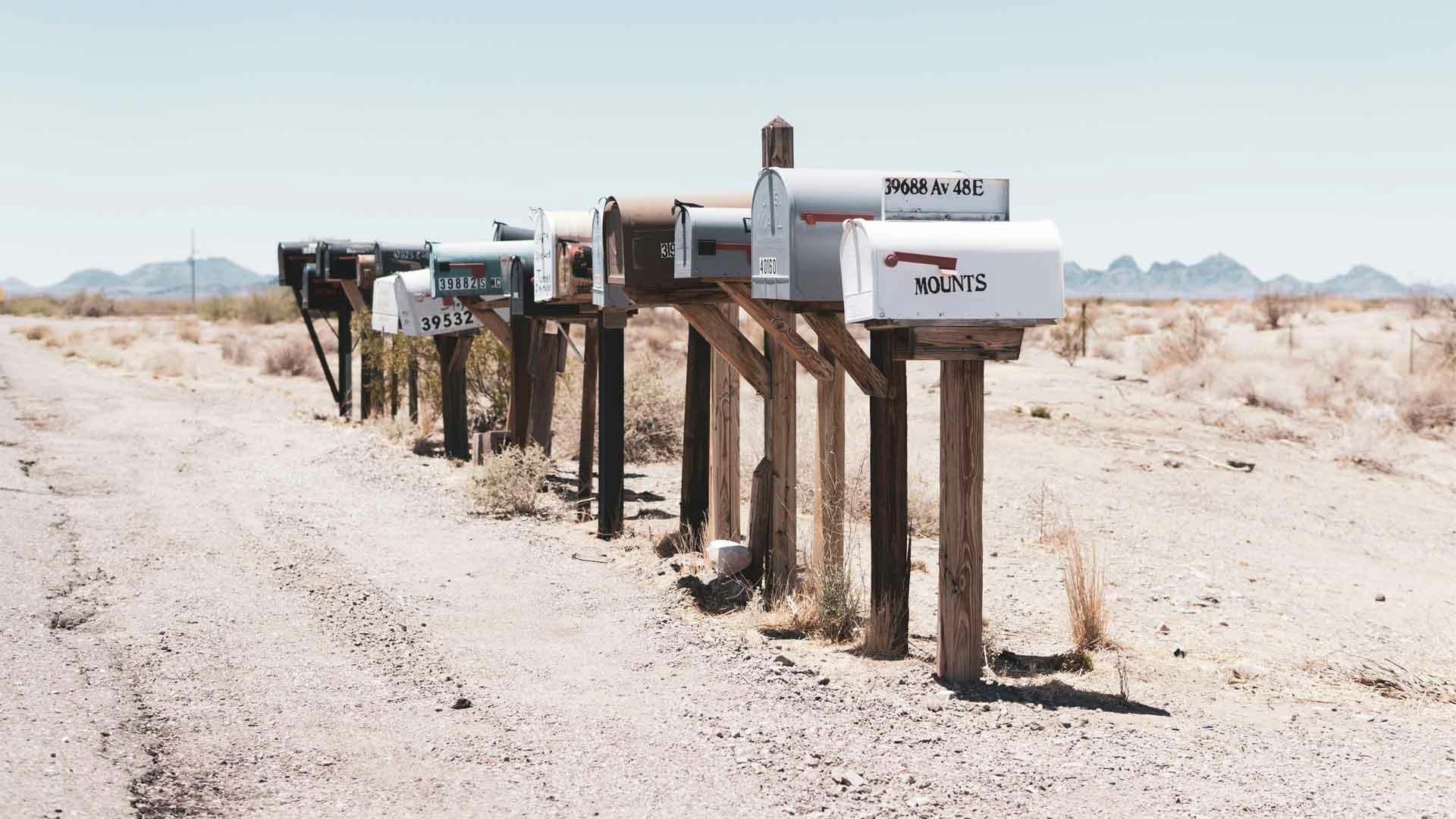 Row of White Mailboxes on a Desert Road